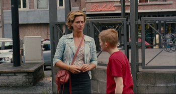 Movie still from “The Kid with a Bike” (2011), directed by Jean-Pierre Dardenne – A woman talking to a young boy on the sidewalk; Medium shot, Over the shoulder angle