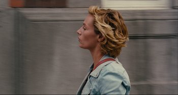Movie still from “The Kid with a Bike” (2011), directed by Jean-Pierre Dardenne – A woman with blonde hair is walking down the street; Close Up shot, Over the shoulder angle