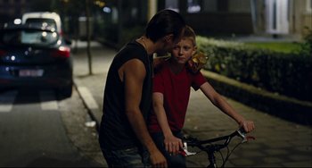 Movie still from “The Kid with a Bike” (2011), directed by Jean-Pierre Dardenne – Two young men on a bicycle at night; Medium shot, Over the shoulder angle