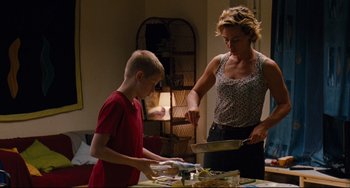Movie still from “The Kid with a Bike” (2011), directed by Jean-Pierre Dardenne – A woman and a boy preparing food at a table; Medium shot, Low angle