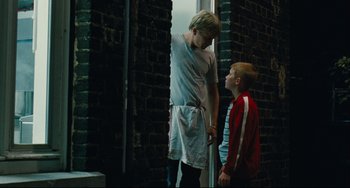 Movie still from “The Kid with a Bike” (2011), directed by Jean-Pierre Dardenne – Two young boys standing next to each other in a room; Medium shot, Over the shoulder angle