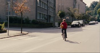 Movie still from “The Kid with a Bike” (2011), directed by Jean-Pierre Dardenne – A boy riding a bike down a street; Extreme Wide shot, High angle