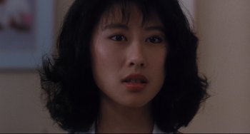 Movie still from “The Killer” (1989), directed by John Woo – A woman's face in a dark room; Close Up shot, Low angle