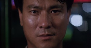 Movie still from “The Killer” (1989), directed by John Woo – A man's face in a dimly - lit room; Close Up shot, Low angle
