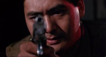Movie still from “The Killer” (1989), directed by John Woo – A person holding a gun; Close Up shot, Low angle