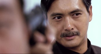 Movie still from “The Killer” (1989), directed by John Woo – A person holding a gun; Close Up shot, Over the shoulder angle