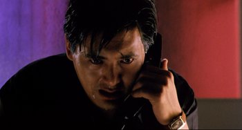 Movie still from “The Killer” (1989), directed by John Woo – A person talking on a cell phone; Close Up shot, Low angle