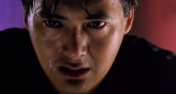 Movie still from “The Killer” (1989), directed by John Woo – A man's face in a dark room; Extreme Close Up shot, Low angle
