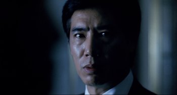 Movie still from “The Killer” (1989), directed by John Woo – A person wearing a suit and tie; Close Up shot, Low angle