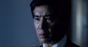 Movie still from “The Killer” (1989), directed by John Woo – A person wearing a suit and tie; Close Up shot, Low angle