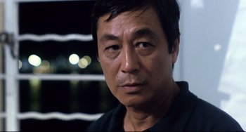 Movie still from “The Killer” (1989), directed by John Woo – A person wearing a black t - shirt; Close Up shot, Over the shoulder angle