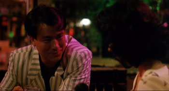 Movie still from “The Killer” (1989), directed by John Woo – A man sitting on a park bench at night; Close Up shot, Over the shoulder angle