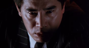 Movie still from “The Killer” (1989), directed by John Woo – A person wearing a suit and tie; Close Up shot, Low angle