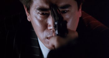 Movie still from “The Killer” (1989), directed by John Woo – A person holding a gun; Close Up shot, Low angle