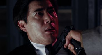 Movie still from “The Killer” (1989), directed by John Woo – A person holding a gun; Close Up shot, Low angle