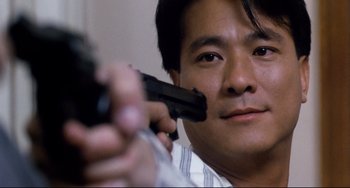 Movie still from “The Killer” (1989), directed by John Woo – A man holding a gun up to his face; Close Up shot, Low angle