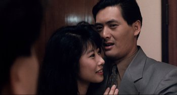 Movie still from “The Killer” (1989), directed by John Woo – A man and a woman posing for a picture; Close Up shot, High angle