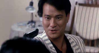 Movie still from “The Killer” (1989), directed by John Woo – A person holding a gun; Close Up shot, Over the shoulder angle