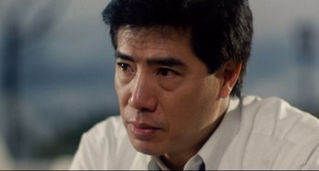 Movie still from “The Killer” (1989), directed by John Woo – A person wearing a white shirt and tie; Close Up shot, Low angle