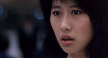 Movie still from “The Killer” (1989), directed by John Woo – A woman's face with a blurry background; Close Up shot, Over the shoulder angle