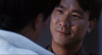 Movie still from “The Killer” (1989), directed by John Woo – A man's face in a room; Close Up shot, Over the shoulder angle