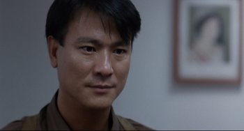 Movie still from “The Killer” (1989), directed by John Woo – A person wearing a brown shirt; Close Up shot, Over the shoulder angle