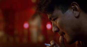 Movie still from “The Killer” (1989), directed by John Woo – A young man holding a cell phone to his mouth; Close Up shot, Low angle