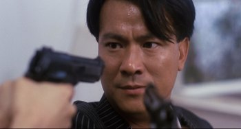 Movie still from “The Killer” (1989), directed by John Woo – A person holding a gun; Close Up shot, Low angle