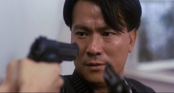 Movie still from “The Killer” (1989), directed by John Woo – A person holding a gun; Close Up shot, Low angle