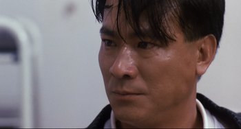 Movie still from “The Killer” (1989), directed by John Woo – A man's face with wet hair; Close Up shot, Low angle