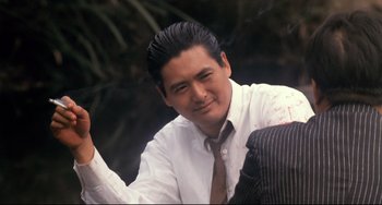 Movie still from “The Killer” (1989), directed by John Woo – A person wearing a suit and tie; Close Up shot, Over the shoulder angle