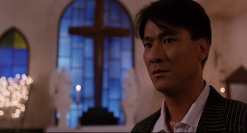 Movie still from “The Killer” (1989), directed by John Woo – A man standing in front of a stained glass window; Close Up shot, Low angle