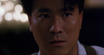 Movie still from “The Killer” (1989), directed by John Woo – A man's face in the dark; Close Up shot, Low angle
