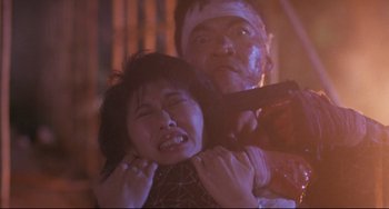 Movie still from “The Killer” (1989), directed by John Woo – A man and a woman are holding each other in the dark; Close Up shot, Low angle