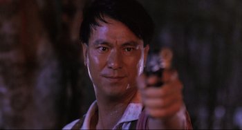 Movie still from “The Killer” (1989), directed by John Woo – A person holding a gun; Close Up shot, Low angle