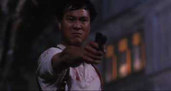 Movie still from “The Killer” (1989), directed by John Woo – A man is holding a gun in his hand; Close Up shot, Low angle