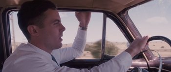 Movie still from “The Killer Inside Me” (2010), directed by Michael Winterbottom – A man driving a car in the middle of the desert; Close Up shot, Low angle