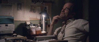 Movie still from “The Killer Inside Me” (2010), directed by Michael Winterbottom – A man sitting at a desk in front of a lamp; Close Up shot, Over the shoulder angle