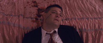Movie still from “The Killer Inside Me” (2010), directed by Michael Winterbottom – A man in a black suit and a red tie; Close Up shot, Overhead angle