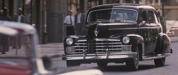 Movie still from “The Killer Inside Me” (2010), directed by Michael Winterbottom – An old car is parked on the side of the street; Wide shot, Low angle