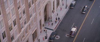 Movie still from “The Killer Inside Me” (2010), directed by Michael Winterbottom – An aerial view of people walking down a sidewalk; Extreme Wide shot, High angle