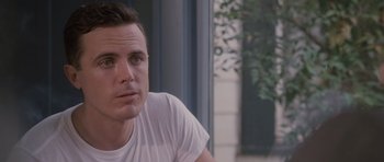 Movie still from “The Killer Inside Me” (2010), directed by Michael Winterbottom – A person wearing a white t - shirt; Close Up shot, Over the shoulder angle