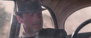 Movie still from “The Killer Inside Me” (2010), directed by Michael Winterbottom – A person wearing a suit and a hat; Close Up shot, Over the shoulder angle