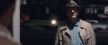 Movie still from “The Killer Inside Me” (2010), directed by Michael Winterbottom – A man wearing a hat and a jacket; Medium shot, Over the shoulder angle