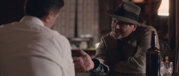 Movie still from “The Killer Inside Me” (2010), directed by Michael Winterbottom – A man wearing a hat and a suit talking to another man in a hat; Close Up shot, Over the shoulder angle