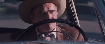 Movie still from “The Killer Inside Me” (2010), directed by Michael Winterbottom – An older man wearing a cowboy hat driving a car; Close Up shot, Low angle