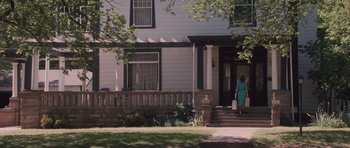 Movie still from “The Killer Inside Me” (2010), directed by Michael Winterbottom – A woman in a blue dress walking down the steps of a house; Wide shot, Over the shoulder angle