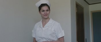 Movie still from “The Killer Inside Me” (2010), directed by Michael Winterbottom – A woman wearing a white nurse's uniform and a hat; Medium shot, Low angle