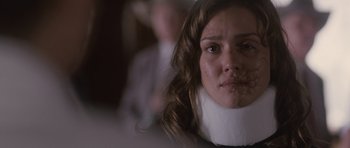 Movie still from “The Killer Inside Me” (2010), directed by Michael Winterbottom – A woman wearing a neck brace looking at the camera; Close Up shot, Over the shoulder angle