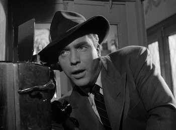 Movie still from “The Killers” (1946), directed by Robert Siodmak – A black and white photo of a man in a suit and a hat; Close Up shot, Low angle